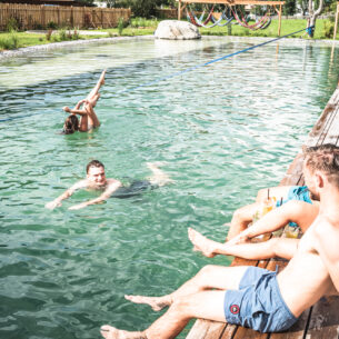Young guests having fun at the natural swimming pool