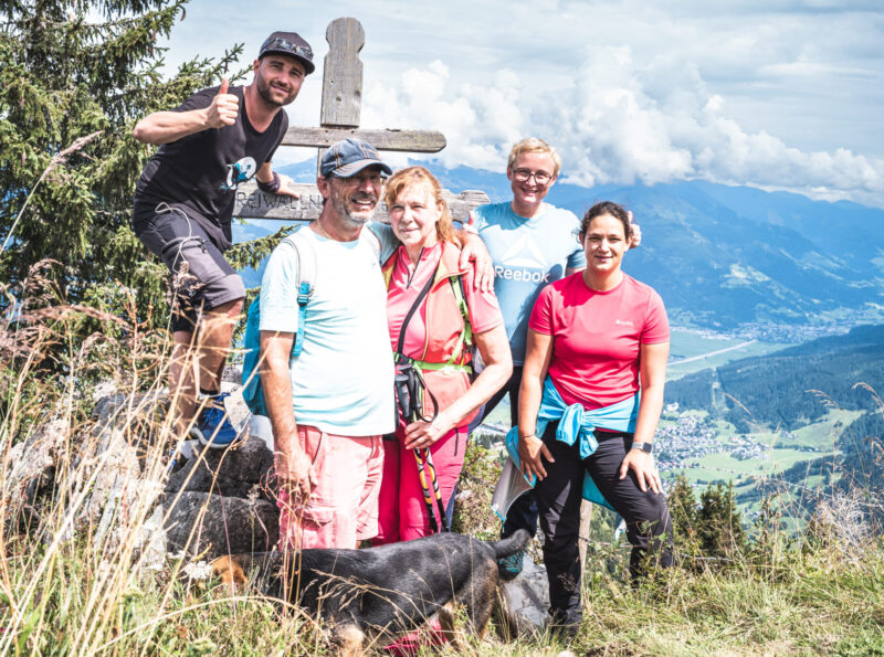 Gruppe von Leuten beim Gipfelkreuz nach einer geführten Wanderung mit Sepp und dem Falken Aktivprogramm