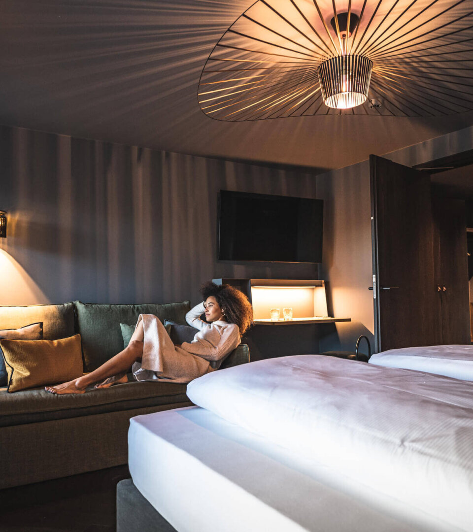 Frau chillt auf der Coach im Studio Vogelfrei im Hotel Falkenstein